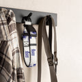 White and purple football dog collar hanging on a wall hook with a shirt and leash