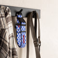 Blue football dog collar hanging on a wall hook with a shirt and leash