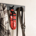 Red football dog collar hanging on a wall hook with a shirt and leash