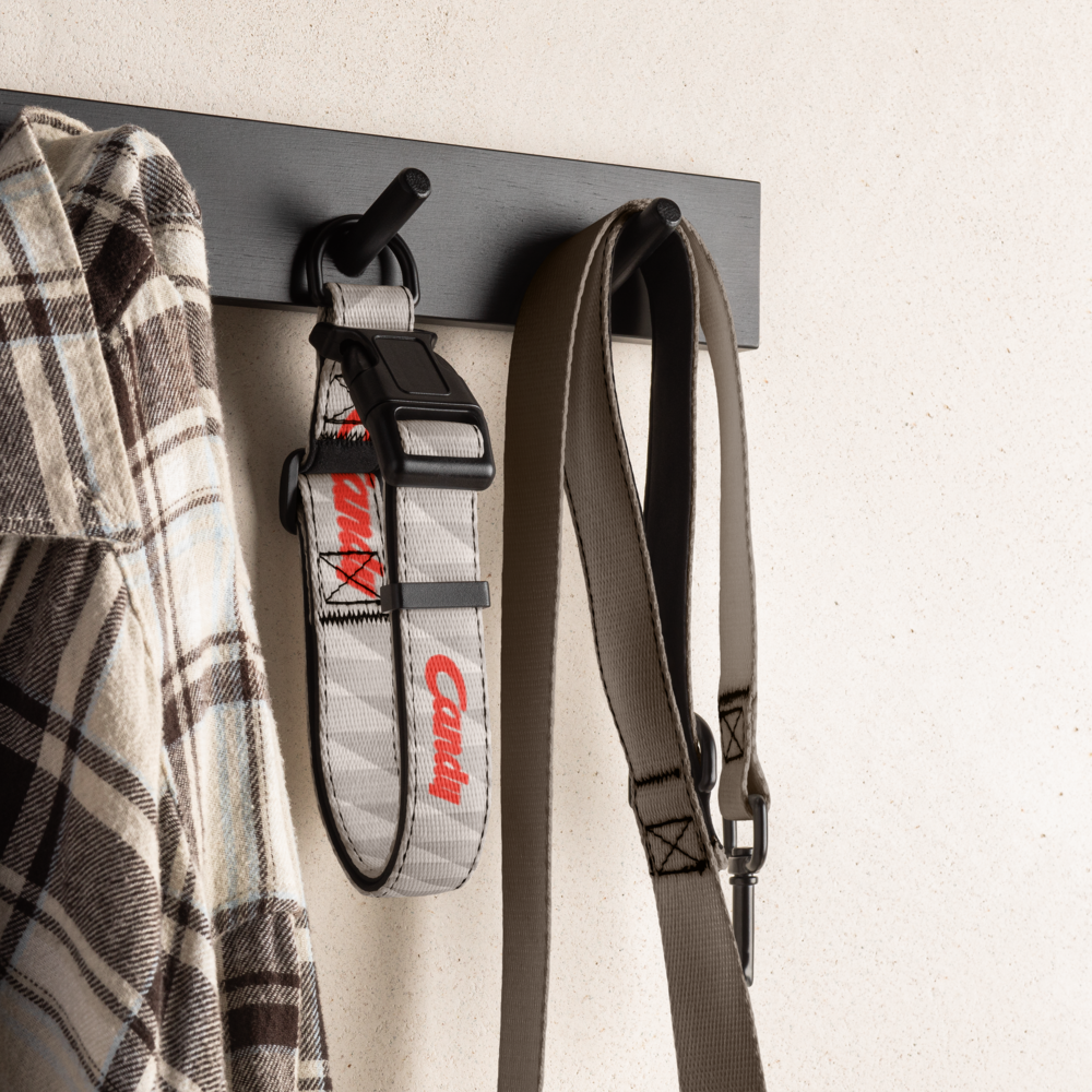 Grey football dog collar hanging on a wall hook with a shirt and leash