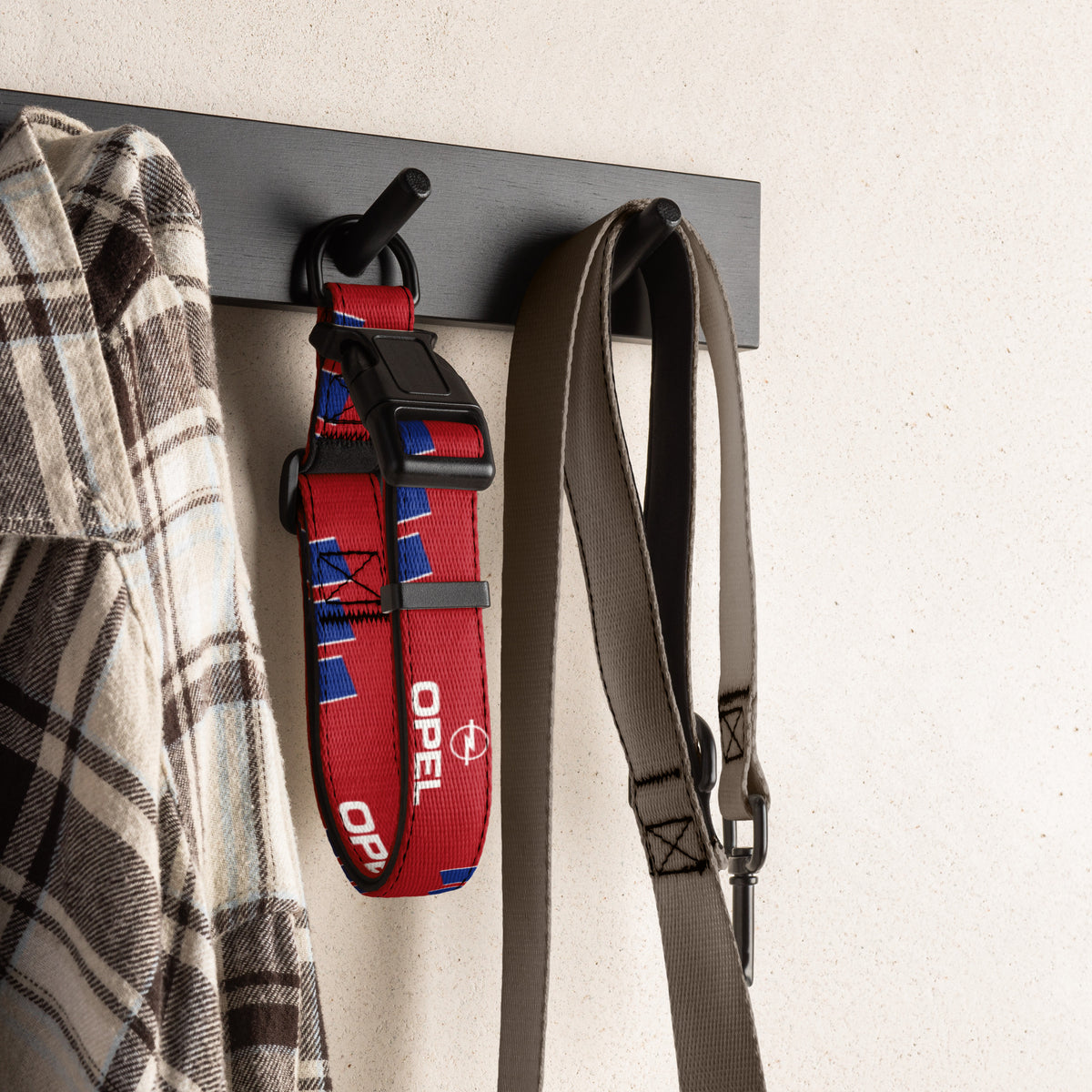 Red and blue football dog collar hanging on a wall hook with a shirt and leash