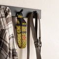Yellow football dog collar hanging on a wall hook with a shirt and leash