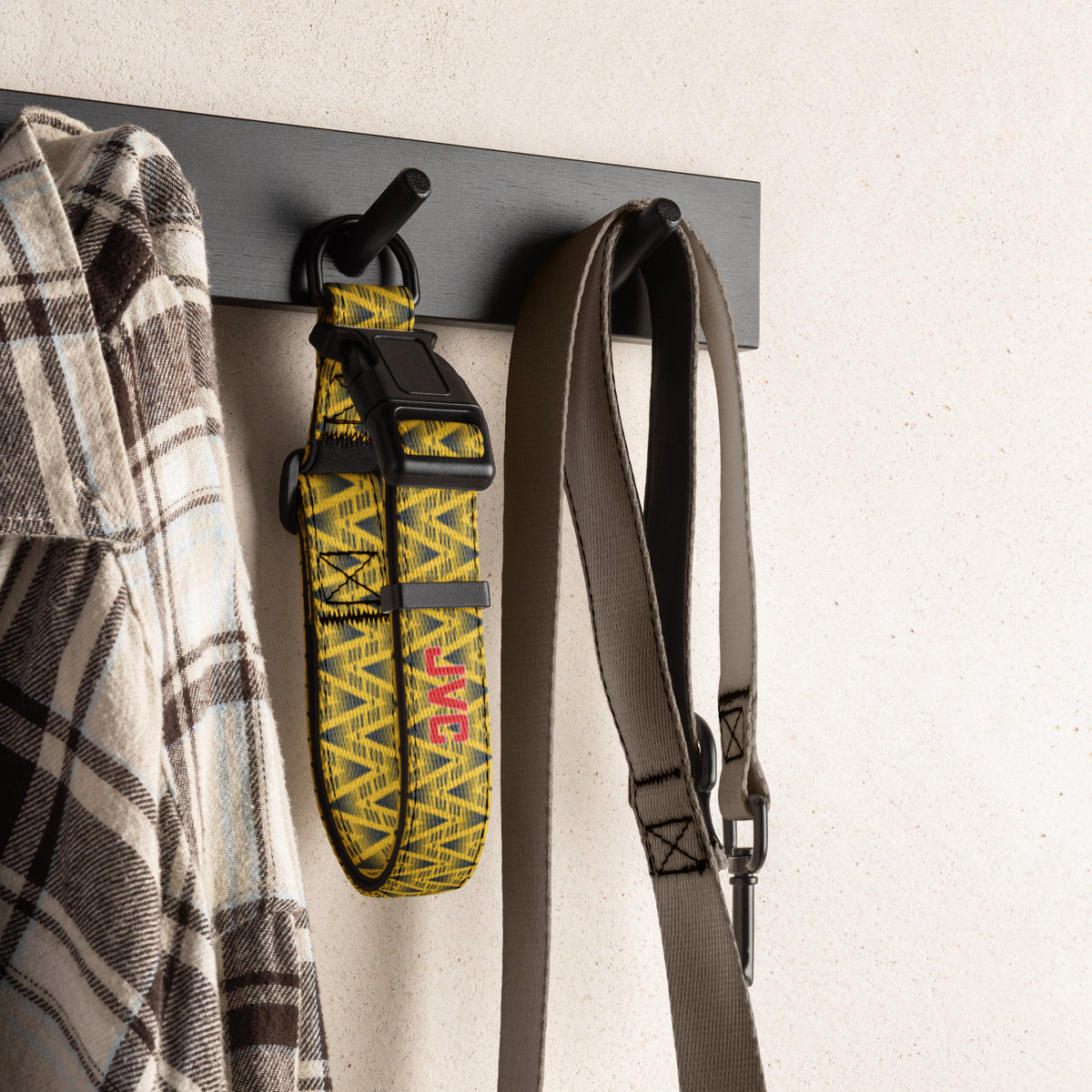 Yellow football dog collar hanging on a wall hook with a shirt and leash