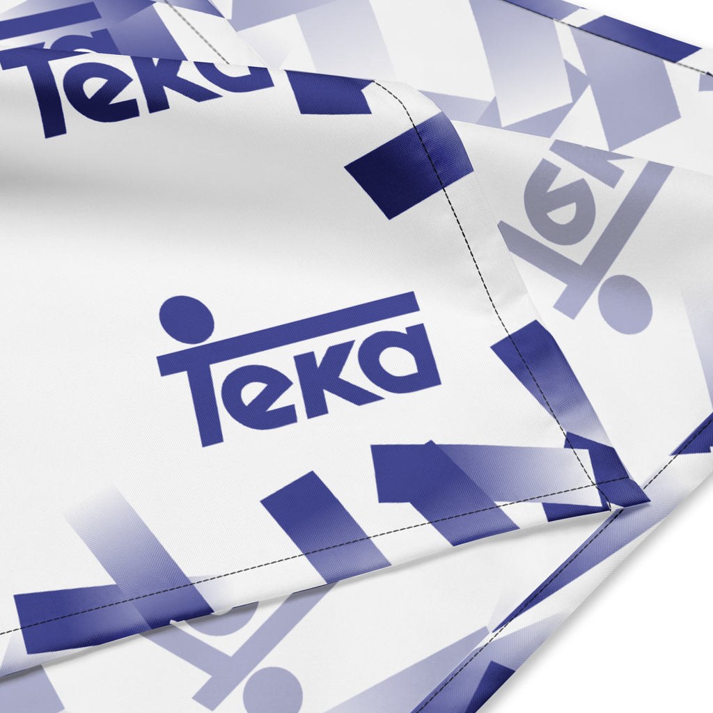 White fabric with a repeating blue and lavender gradient geometric pattern and the word 'teka' printed prominently in blue.