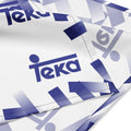 White fabric with a repeating blue and lavender gradient geometric pattern and the word 'teka' printed prominently in blue.
