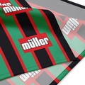 A close-up of a striped textile product, likely a bandana or scarf, featuring green, black, and red vertical stripes with the white 'müller' logo repeated across the design.