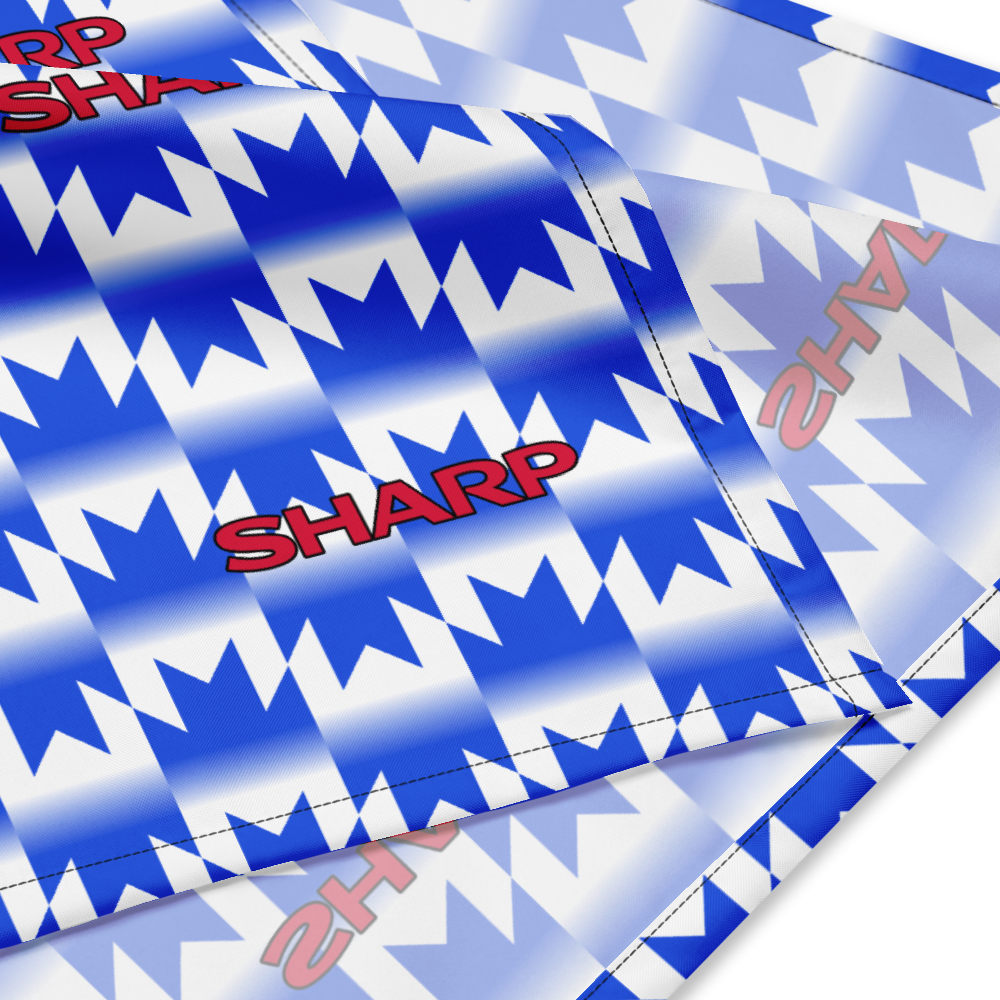 A close-up of a blue and white patterned fabric product, likely a flag or banner, featuring a repeating chevron design and the word 'SHARP' printed in red.