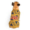 A small tan dog viewed from behind wearing a yellow knit pet sweater with a navy geometric pattern and a red 'JVC' logo on the back, photographed on a clean white background.