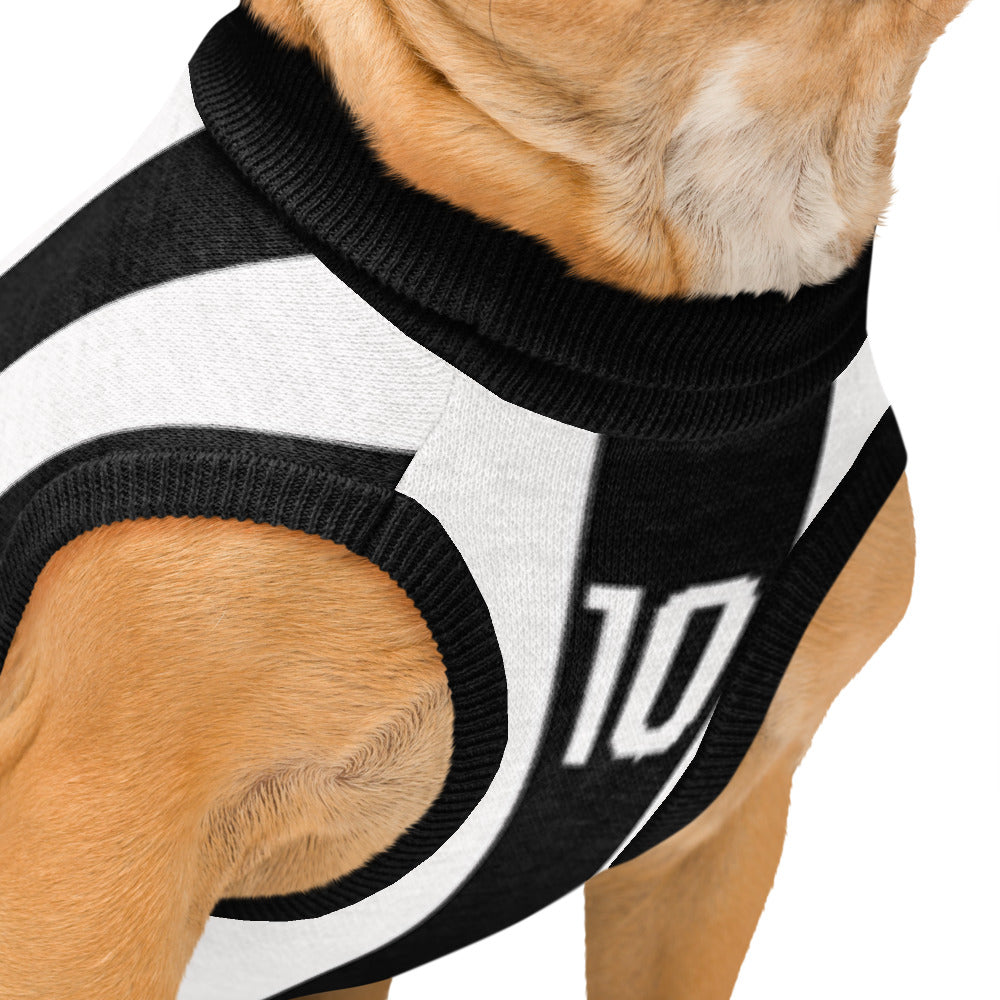 A close-up of a dog wearing a black and white knit sports jersey-style pet shirt with the number 10 printed on the side, against a plain white background.