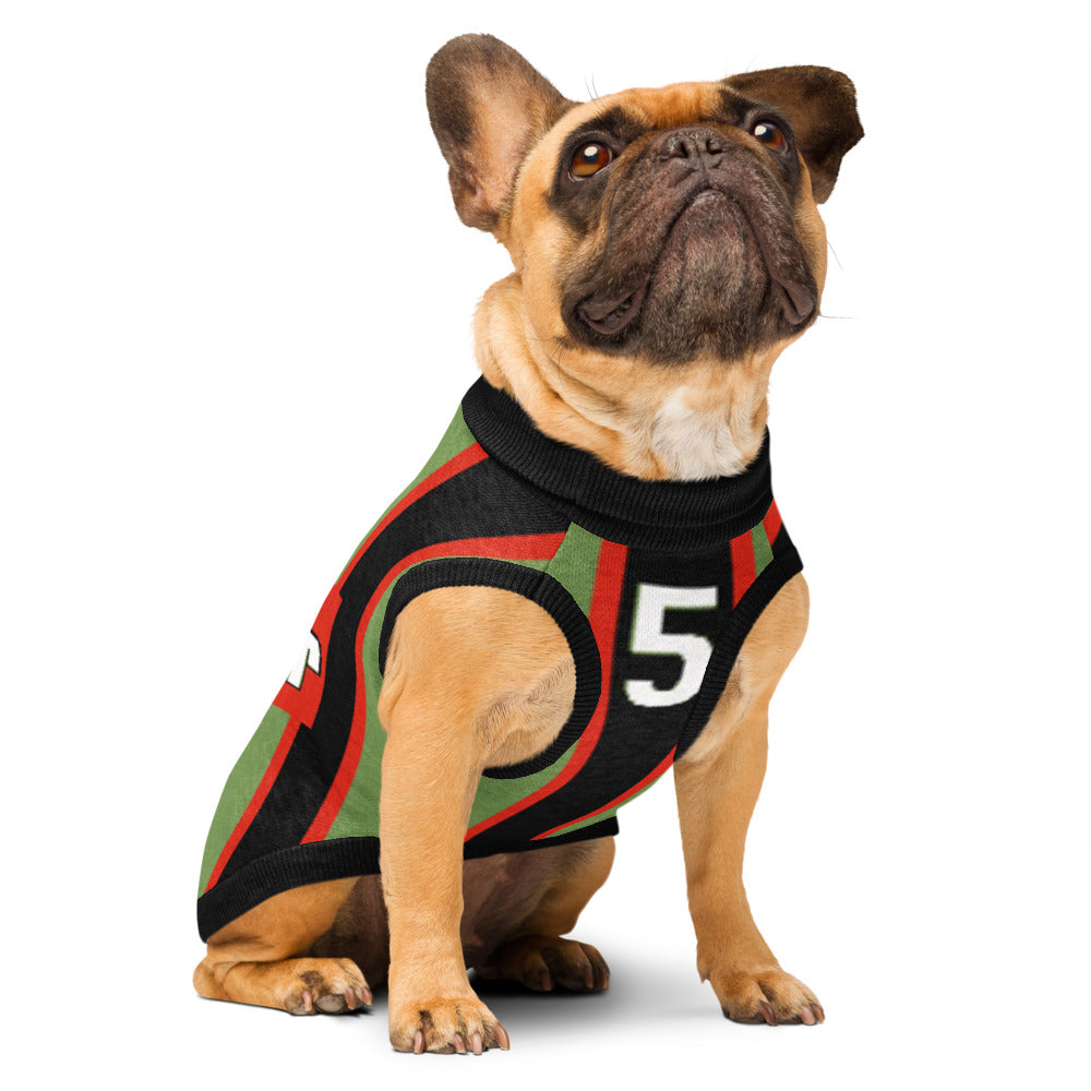 A fawn French bulldog wearing a black knit dog sweater with red and green stripes and a white number 5 on the front, photographed against a solid white background.