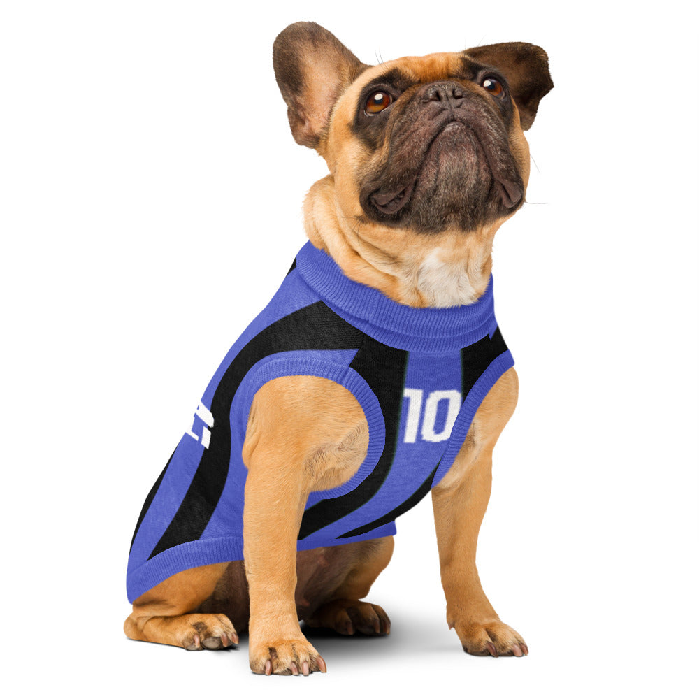 A fawn French bulldog wearing a blue and black athletic dog shirt with the number 10, sitting against a solid white background.